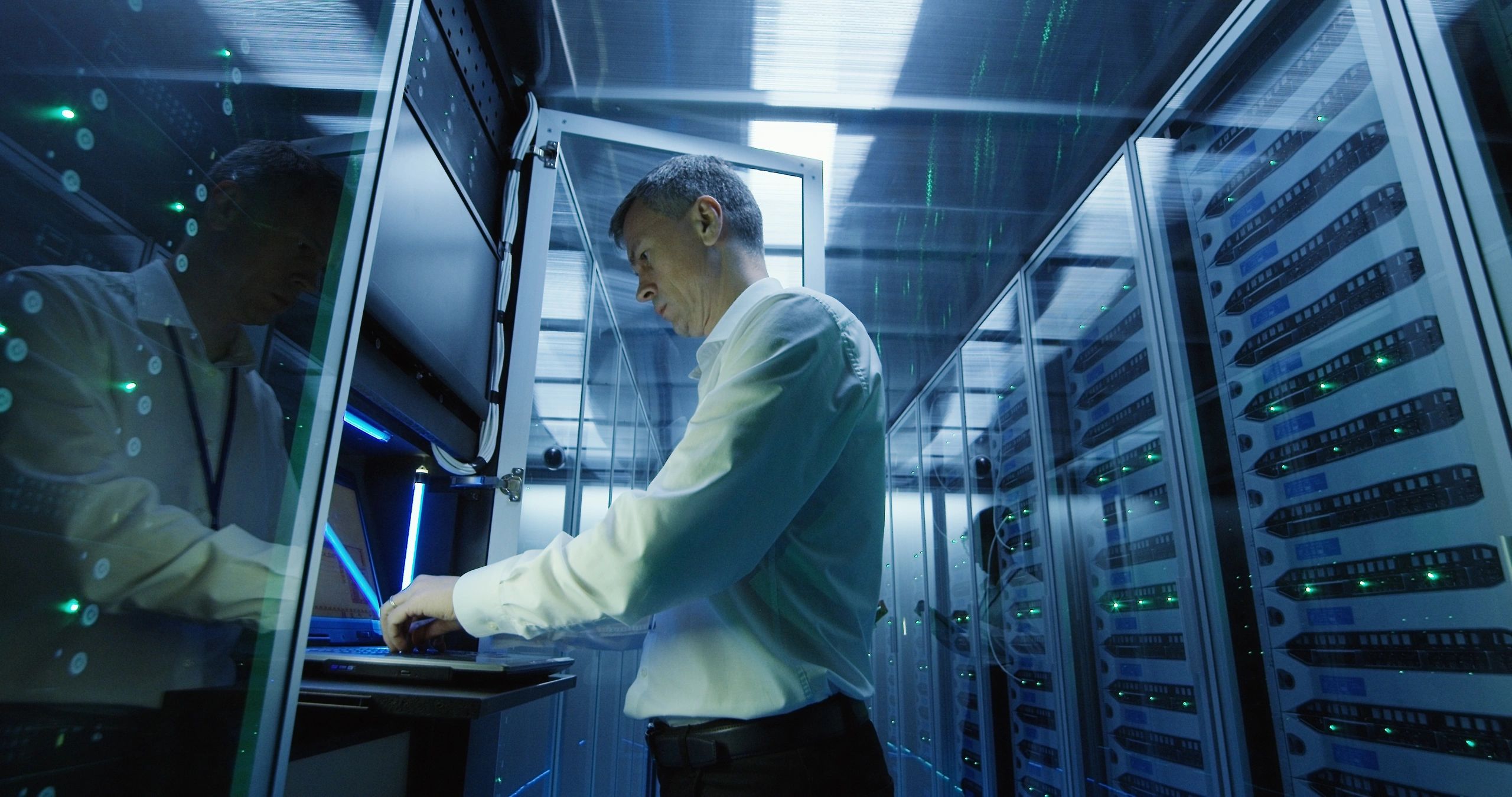 Technician working on a laptop in a data center