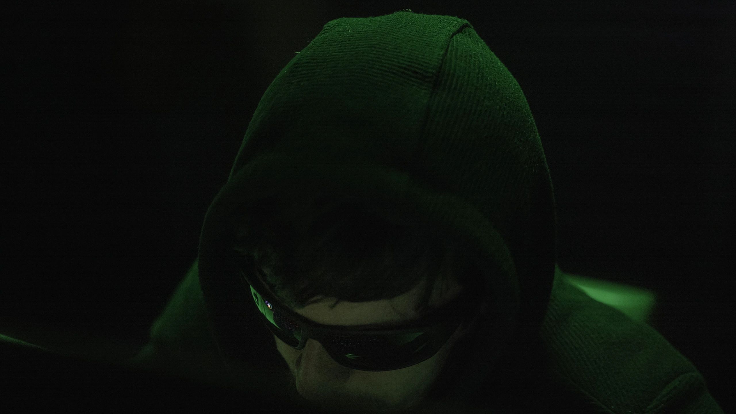 Close-up of hands typing on a laptop in a dark workspace
